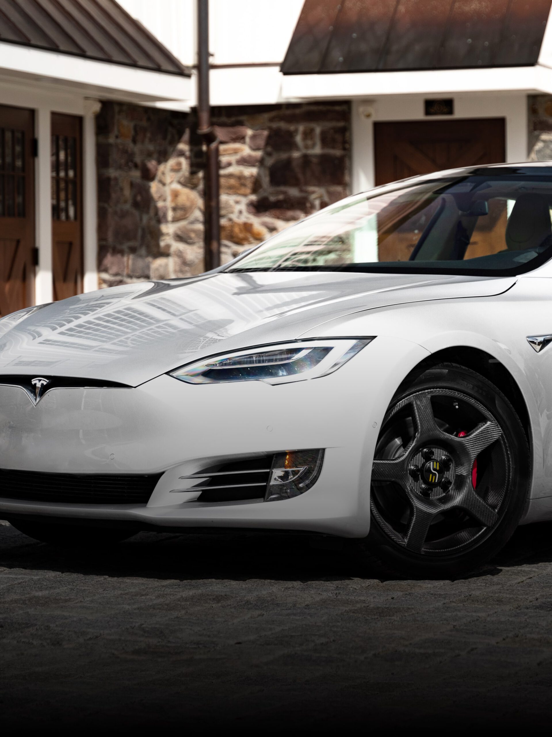 the front-end of a white Tesla with carbon fiber wheels