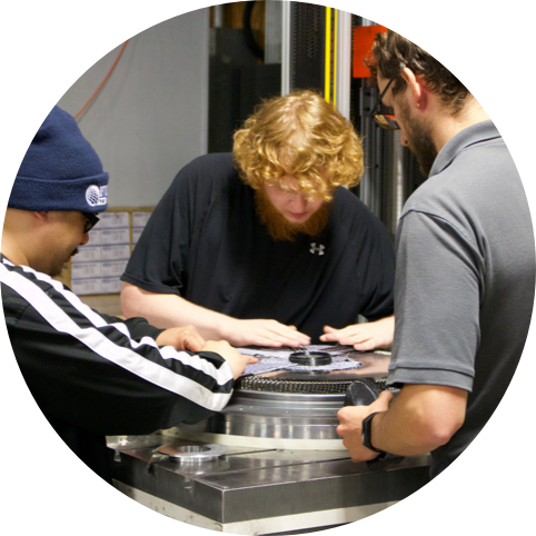 three engineers working on producing a carbon fiber wheel